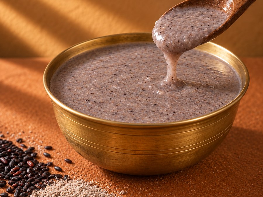 Bowl of ragi porridge being served with a wooden spoon